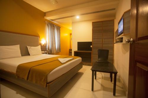 una camera d'albergo con letto e TV di P K Rresidency a Madurai