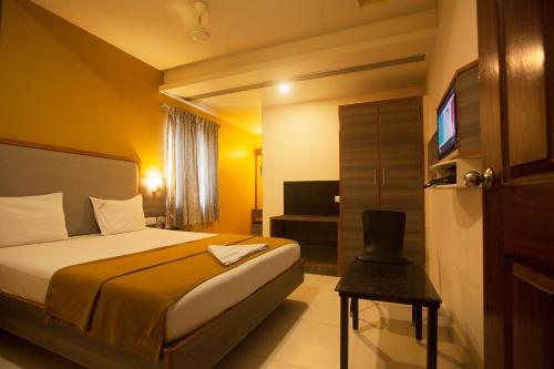 a hotel room with a bed and a television at P K Rresidency in Madurai