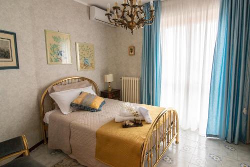 Schlafzimmer mit einem Bett mit blauen Vorhängen und einem Kronleuchter in der Unterkunft Residenza Le Terrazze di Gualdo Rent Rooms in Gualdo Tadino