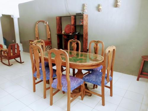a dining room with a glass table and chairs at Casa Ixchel - 450m to Downtown, WiFi, Hot Water, AC in Valladolid