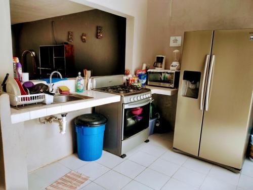 eine Küche mit einem Herd und einem Kühlschrank in der Unterkunft Casa Ixchel - 450m to Downtown, WiFi, Hot Water, AC in Valladolid