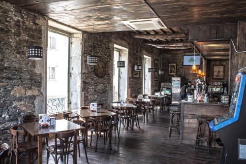 un restaurante con mesas y sillas y un bar en Roots&Boots Lugo, en Lugo
