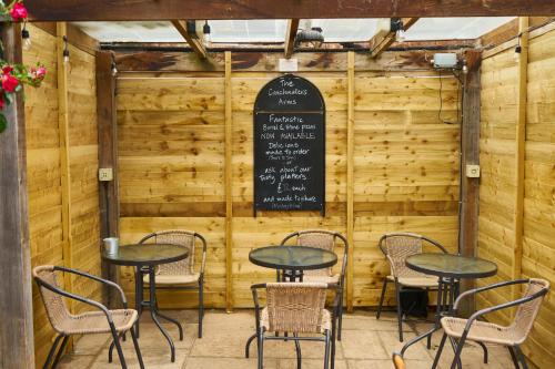 um restaurante com mesas e cadeiras em frente a uma parede de madeira em The Coachmakers Arms em Wallingford