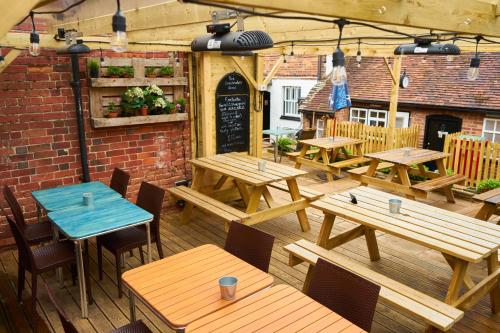 a wooden table topped with wooden chairs next to a patio at The Coachmakers Arms in Wallingford