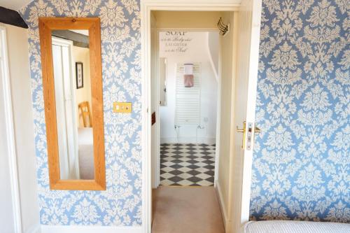 a hallway with blue and white wallpaper and a mirror at The Coachmakers Arms in Wallingford