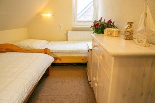 a small bedroom with two beds and a counter with flowers at Ferienwohnung Wiebke -Ferien in Almdorf in Almdorf