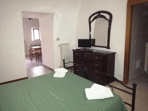 a bedroom with a green bed with a dresser and a mirror at Holiday Residence in Casamassima