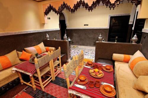 a living room with a couch and a table with food on it at Atlas Mazik Lodge mountain views in Imlil