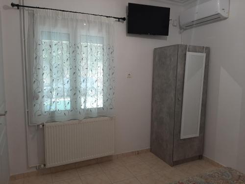 a room with a window with a mirror and a television at Mark's Twins in Volos