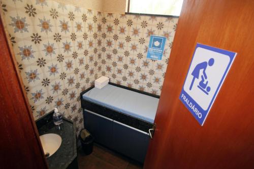 a bathroom with a toilet and a door with a sign at Carpe Diem Eco Resort Olímpia in Olímpia