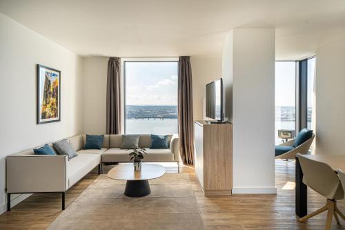 a living room with a couch and a tv at INNSiDE by Meli&aacute; Liverpool in Liverpool