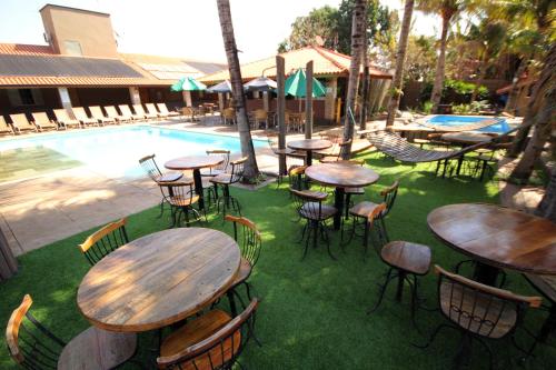 a group of tables and chairs next to a pool at Carpe Diem Eco Resort Olímpia in Olímpia