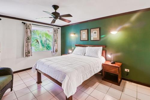um quarto com uma cama e uma parede verde em Pueblo Real Resort em Quepos