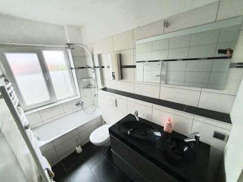 a bathroom with a sink and a toilet and a mirror at Pottmensch Oberhausen 3 Schlafzimmer in Oberhausen