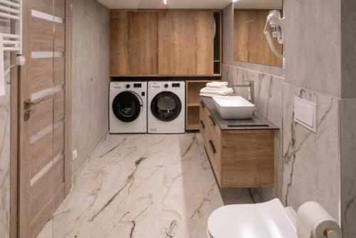 La salle de bains est pourvue d'un lave-linge et d'un sèche-linge. dans l'établissement NOMAD APARTMENTS, à Mažeikiai
