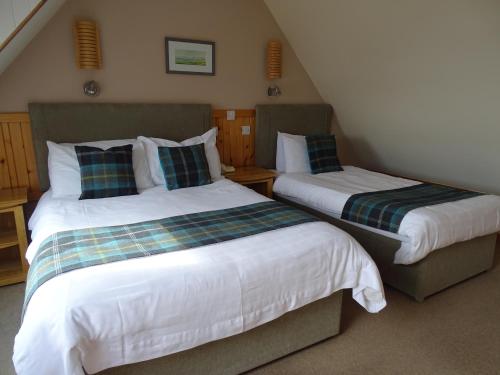 2 łóżka w małym pokoju z: w obiekcie The Sands Hotel, Orkney w mieście Burray Village