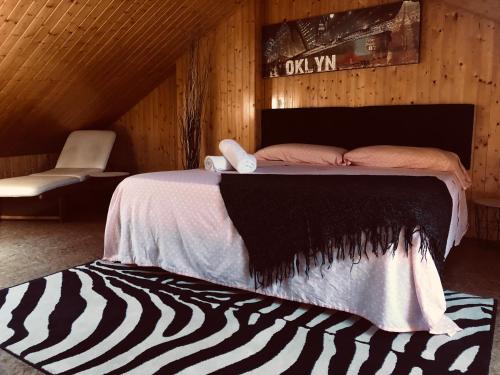 Cama en habitación de madera con alfombra de cebra en Villa turística Camina y Rioja en Cenicero