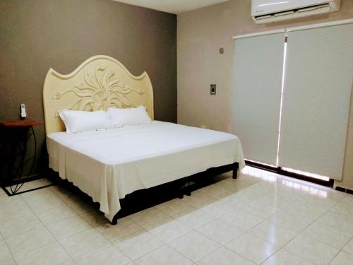 a bedroom with a large white bed with a large window at Casa Ixchel - 700m to Downtown, WiFi, Hot Water, AC in Valladolid