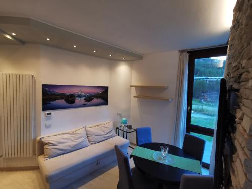 - un salon avec un canapé et une table dans l'établissement Flamma Apartment - Ski in & Ski Out, à Breuil-Cervinia