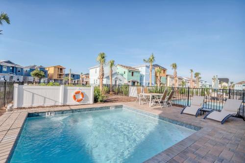 a swimming pool with chairs and a table and houses at Margaritaville Cottage, PRIVATE POOL, Near Disney in Orlando