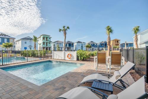 a swimming pool with palm trees and houses at Margaritaville Cottage, PRIVATE POOL, Near Disney in Orlando