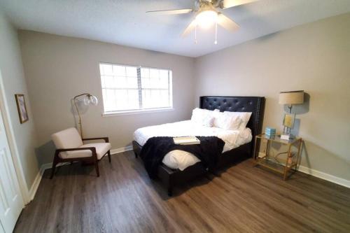 a bedroom with a bed and a chair and a window at Modern Designer Townhouse 2Br Ideal for Long Stays! in Jackson