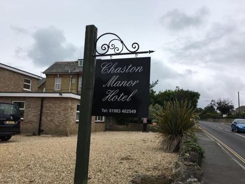 a sign in front of a building next to a street at Chaston Manor Hotel in Sandown
