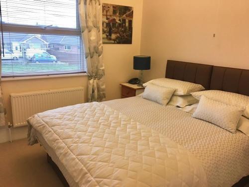 a bedroom with a large white bed and a window at Chaston Manor Hotel in Sandown