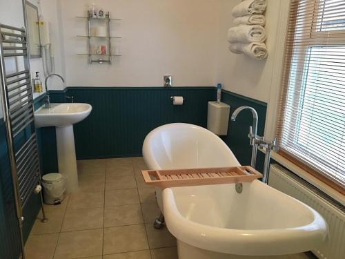 a bathroom with a white tub and a sink at Chaston Manor Hotel in Sandown