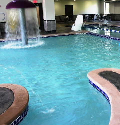 a swimming pool with a fountain in a building at Holiday Inn Express & Suites Columbus - Polaris, an IHG Hotel in Columbus