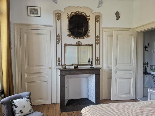 グイネスにあるLe Sophoraの暖炉と壁掛け鏡付きの部屋