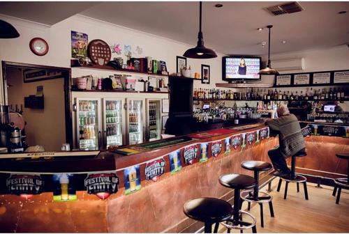 a man standing at a bar in a pub at The Miners Rest Motel in Kalgoorlie