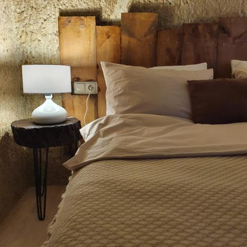 a bedroom with a bed with a lamp on a table at Deep Cave House in Urgup