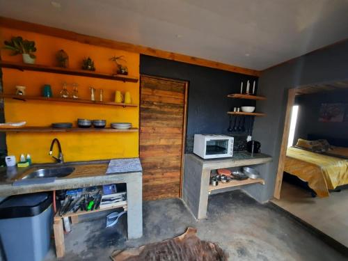 una cocina con fregadero y una cama en una habitación en Vulture's View 1, en Hartbeespoort