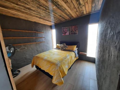 a bedroom with a bed and a wooden ceiling at Vulture's View 1 in Hartbeespoort