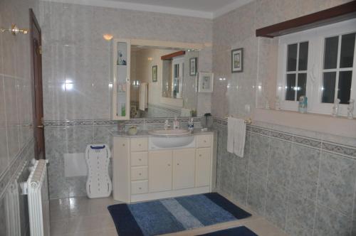 La salle de bains est pourvue d'un lavabo et d'un miroir. dans l'établissement O cantar dos passarinhos, à Fátima