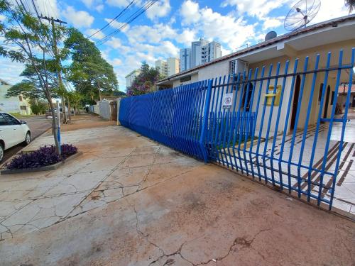 uma cerca azul do lado de um edifício em Pousada Catarina em Maringá