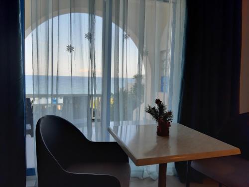 a table and a chair in front of a large window at villa vagelis in Mourteri