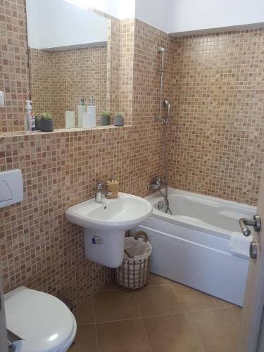 a bathroom with a sink and a tub and a toilet at Vita Bella Sinaia in Sinaia