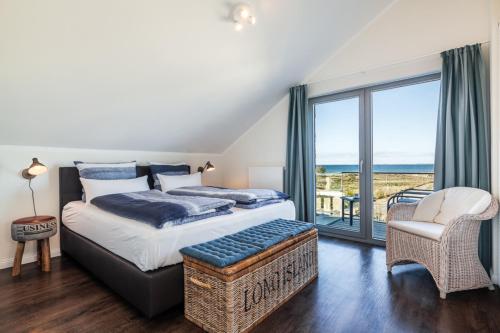 ハイリゲンハーフェンにあるOstsee - Appartement Nr 82 "MeerGlück" im Strand Resortのベッドルーム1室(ベッド1台付)、海を望むバルコニーが備わります。