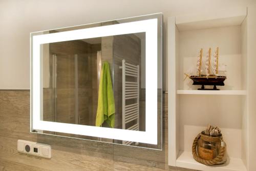 a mirror in a bathroom with a boat on a shelf at Whg 11 - Sonnencamp in Zingst