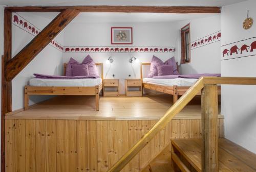 two beds in a room with a staircase at Vlčihorská chaloupka in Krásná Lípa