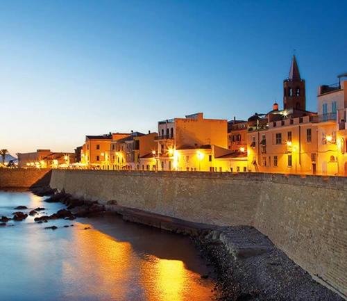 a group of buildings next to a river at night at Casa Vacanze San Michele in Alghero