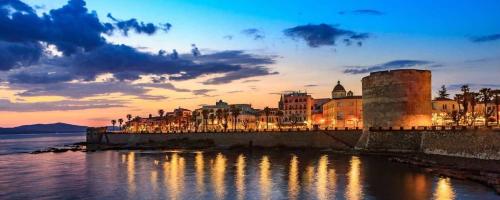 a view of a city with lights on the water at Casa Vacanze San Michele in Alghero