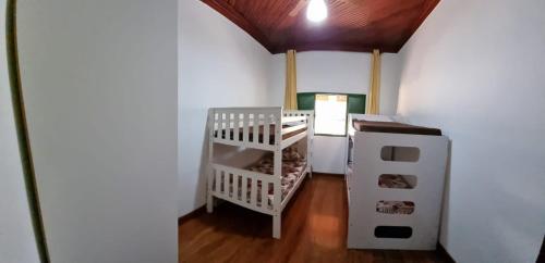 a small room with a refrigerator and a shelf at Sítio Sebastião Pereira in Jambeiro