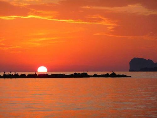 a sunset over a body of water with the sun at Casa Vacanze San Michele in Alghero
