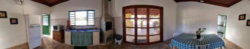 a living room with a table and two windows at Sítio Sebastião Pereira in Jambeiro