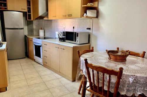 a kitchen with a table with a microwave and a refrigerator at Lava House in Mandrákion