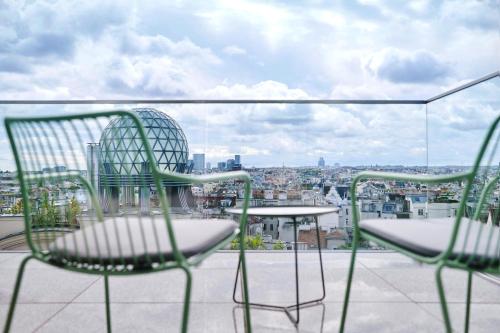two chairs and a table on a balcony with a view at Jaz in the City Vienna in Vienna
