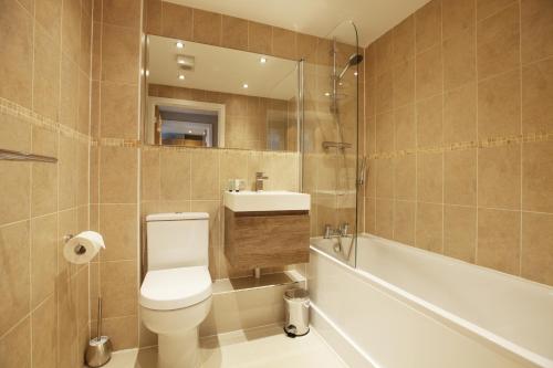 a bathroom with a toilet and a sink and a tub at Urban Living's - The Wesley Beautiful City Centre Apartment with Balcony in Oxford